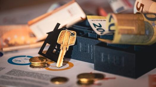 pexels-photo-29799518-29799518 Close-up of house keys, euro bills, and charts symbolizing real estate investment and finance.