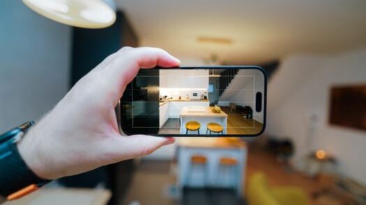 pexels-photo-30332467-30332467 A smartphone in focus capturing a modern kitchen interior, showcasing real estate potential.
