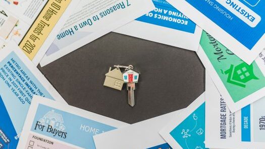 pexels-photo-8293714-8293714 Overhead view of real estate brochures and house key, ideal for marketing.
